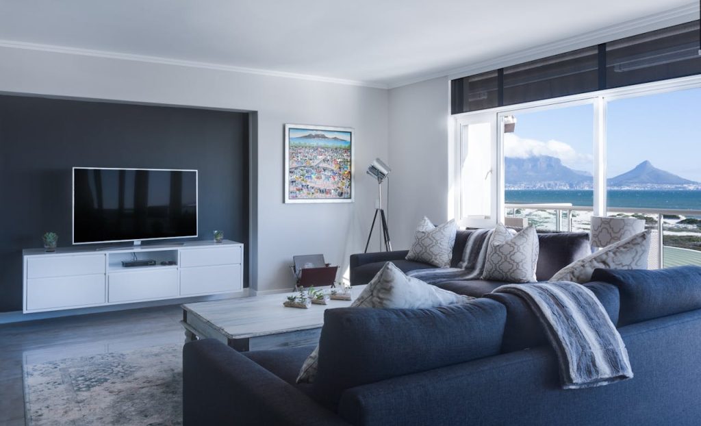 About Us Stylish living room with a view of Table Mountain, blending modern design with natural beauty.